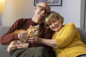 Casal de idosos feliz ao lado de seu gato.