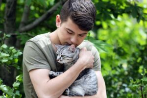Jovem abraçando seu gato.