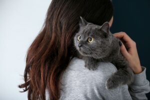 Mulher abraçada com gato.
