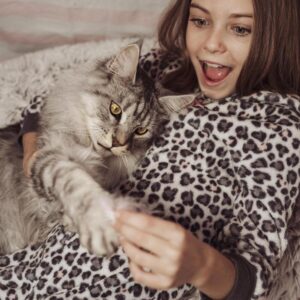 Menina brincando com gato Maine Coon.