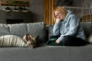 Mulher olhando seu cachorro deitado no sofá.